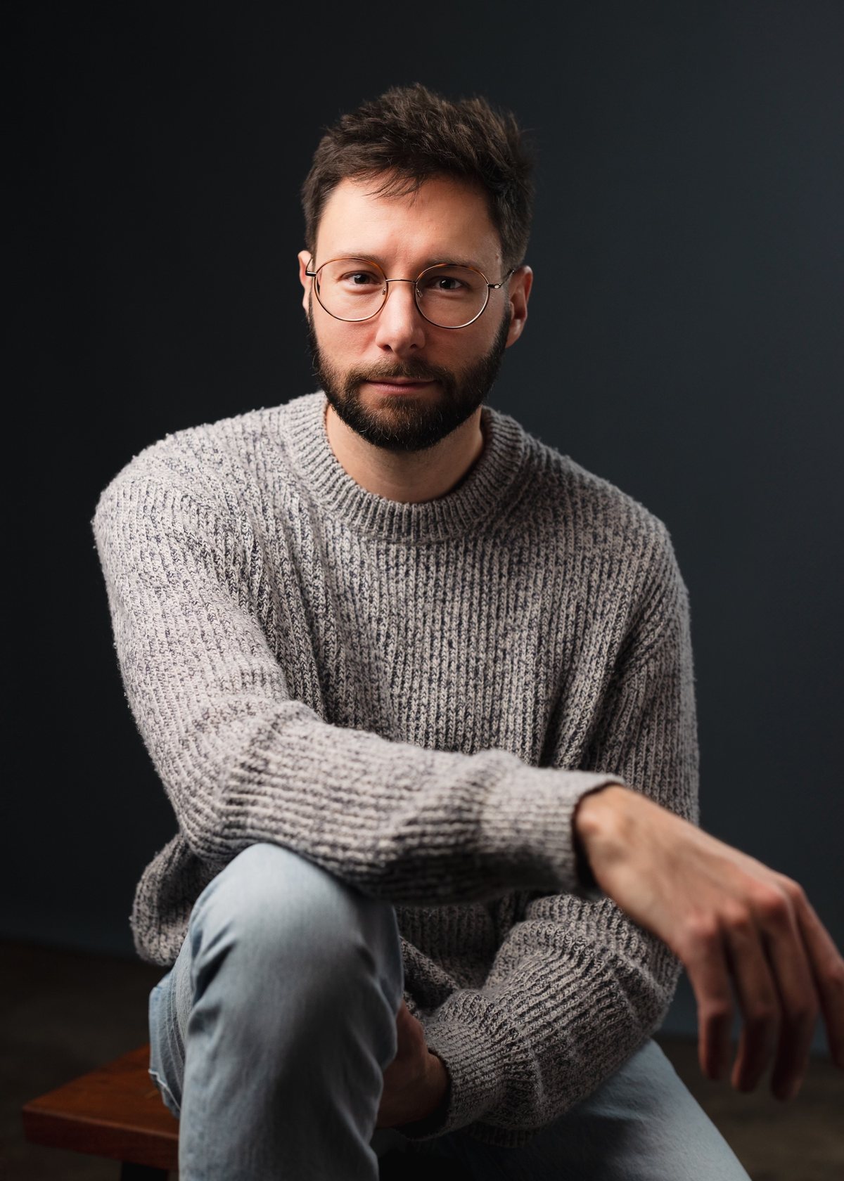 Matt, who records as Ruffner, seated in a grey knit sweater.